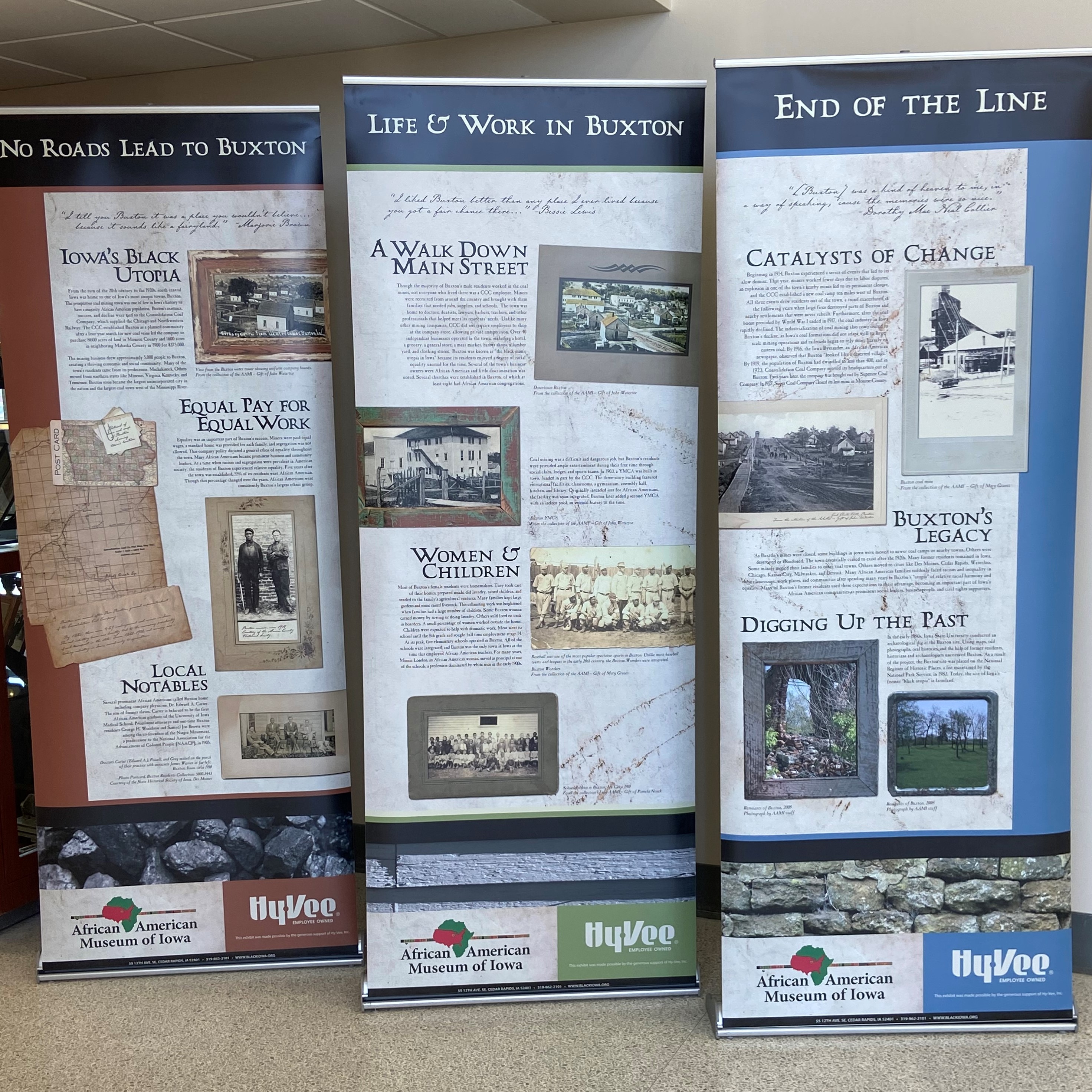 Three retractable banners on the floor of the Polk County Administration Building that say, 'No Roads Lead to Buxton', 'Life & Work in Buxton', and 'End of The Line.'